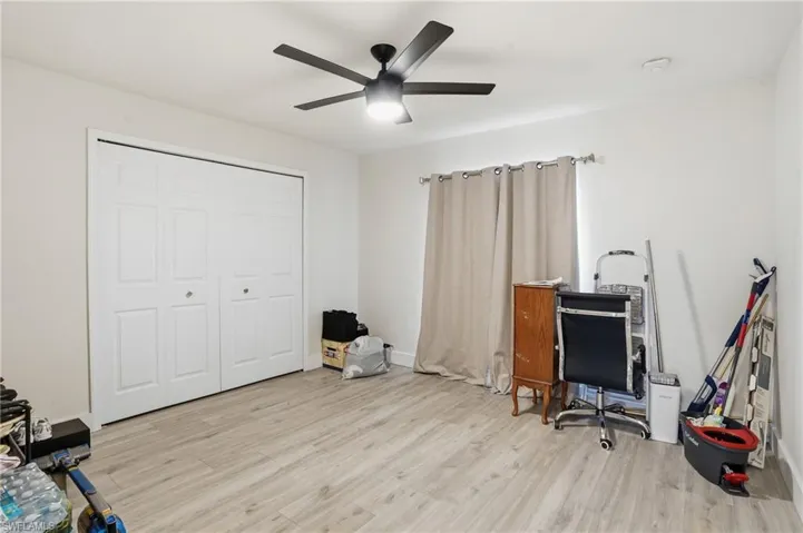 Office space with light wood-style flooring and a ceiling fan