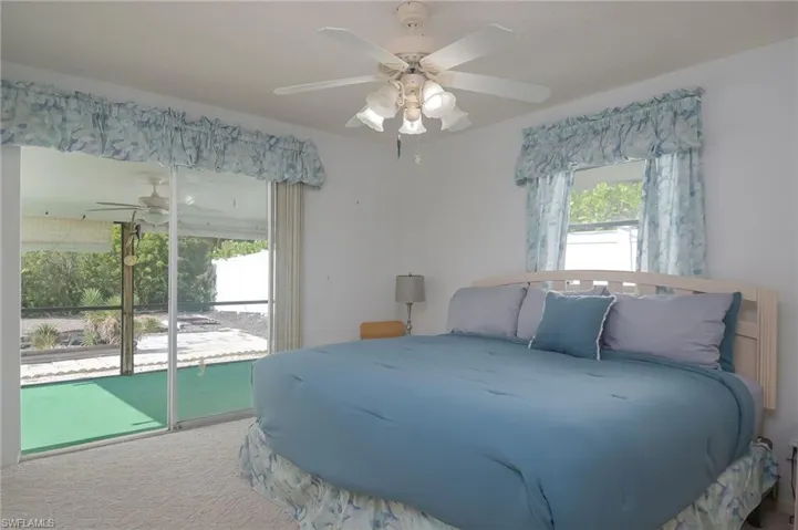 Bedroom featuring carpet, ceiling fan, multiple windows, and access to outside