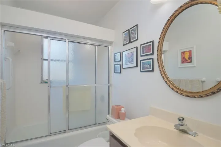 Full bathroom with vanity, toilet, and enclosed tub / shower combo