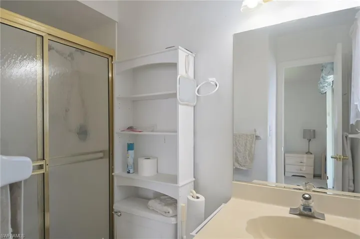 Bathroom with a shower with door, sink, and toilet