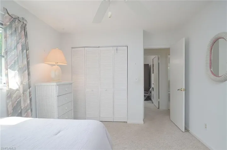 Carpeted bedroom featuring a closet and ceiling fan