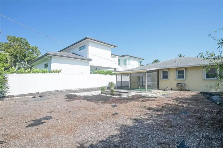 Rear view of house with a screened-in lanai area and plenty of room to add a pool