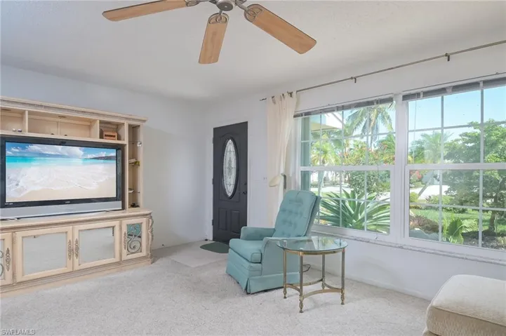 Living area featuring ceiling fan and carpet floors