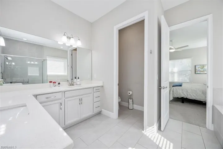 Bathroom featuring a shower stall, vanity, and light tile patterned floors