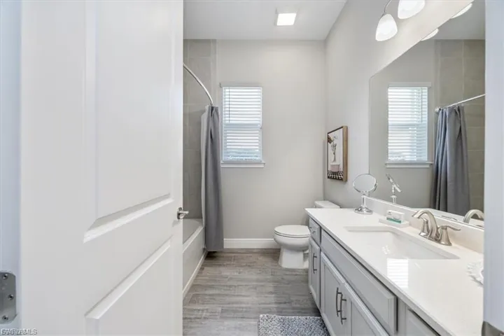Full bathroom featuring vanity, light wood-style floors, and shower / bath combo with shower curtain