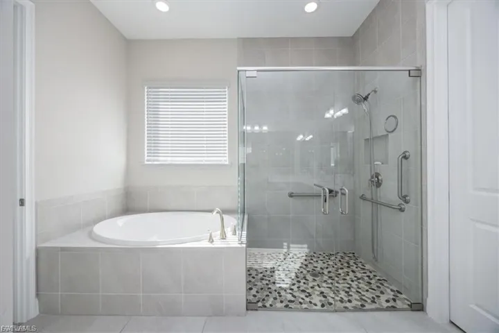 Bathroom with a stall shower, a garden tub, tile patterned flooring, and recessed lighting