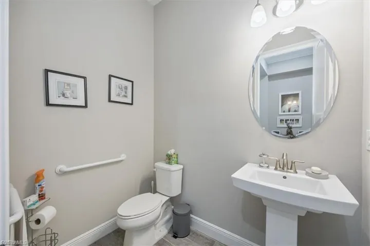 Half bathroom featuring baseboards and toilet