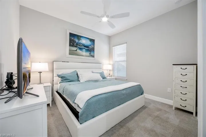 Bedroom with ceiling fan and light colored carpet