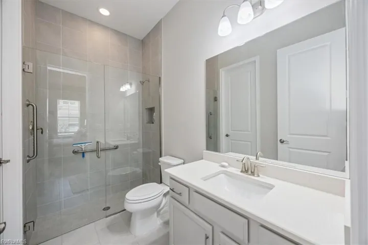 Bathroom with vanity, a shower stall, recessed lighting, and light tile patterned floors