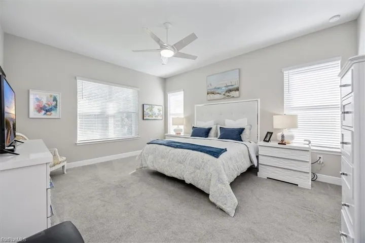 Bedroom with light colored carpet and ceiling fan