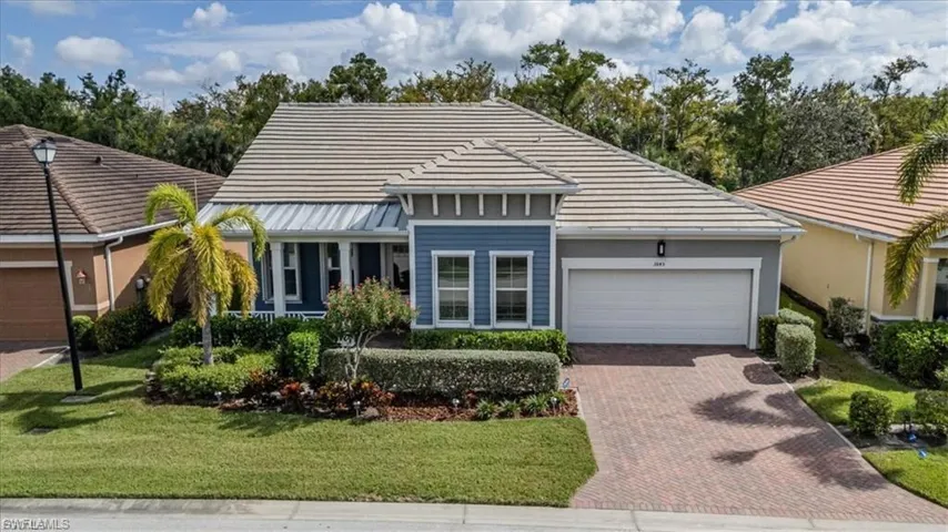 View of front facade with an attached garage, decorative driveway, and a front lawn