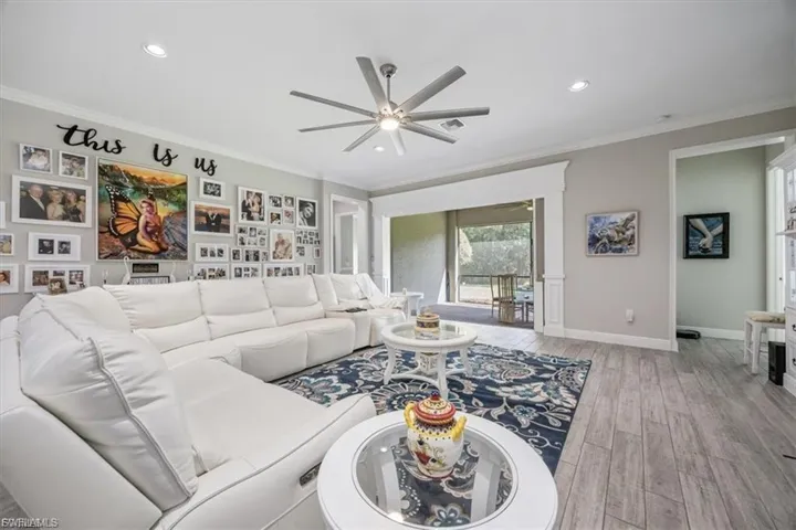 Living room featuring ornamental molding, wood finished floors, ceiling fan, and recessed lighting