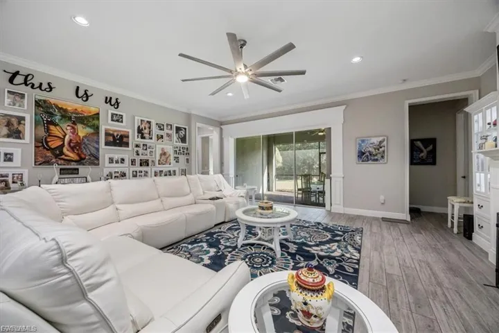 Living area with light wood-type flooring, ornamental molding, ceiling fan, and recessed lighting