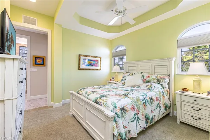 oversized guest bedroom has lovely tray ceiling with tons of natural light
