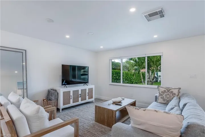Living room with baseboards, visible vents, carpet flooring, and recessed lighting