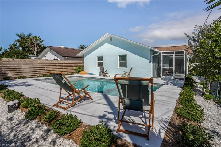 View of pool featuring a sunroom, fence, a fenced in pool, and a patio