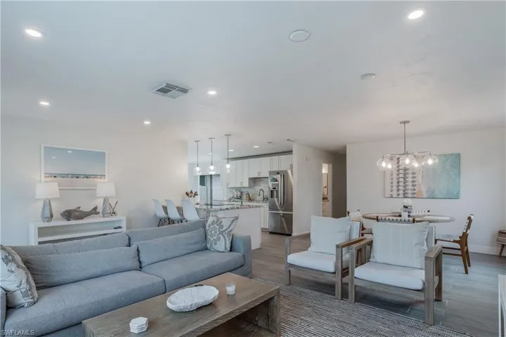 Living area with a chandelier, wood finished floors, visible vents, and recessed lighting