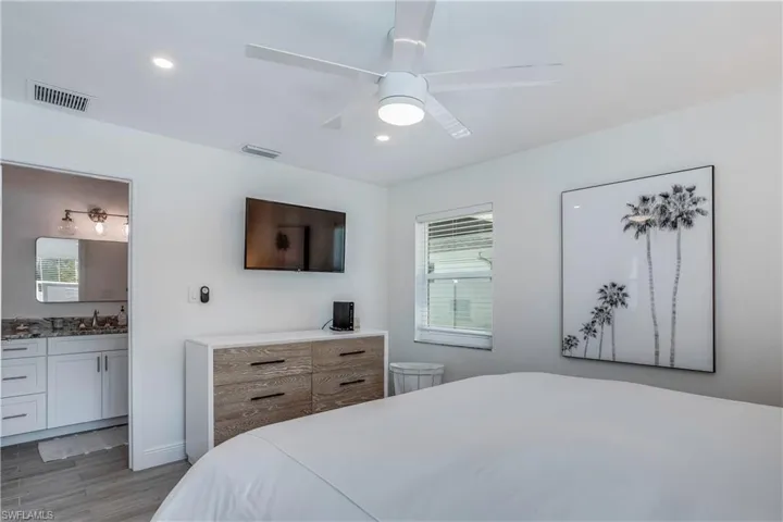 Bedroom with visible vents, ensuite bath, light wood-type flooring, a sink, and recessed lighting