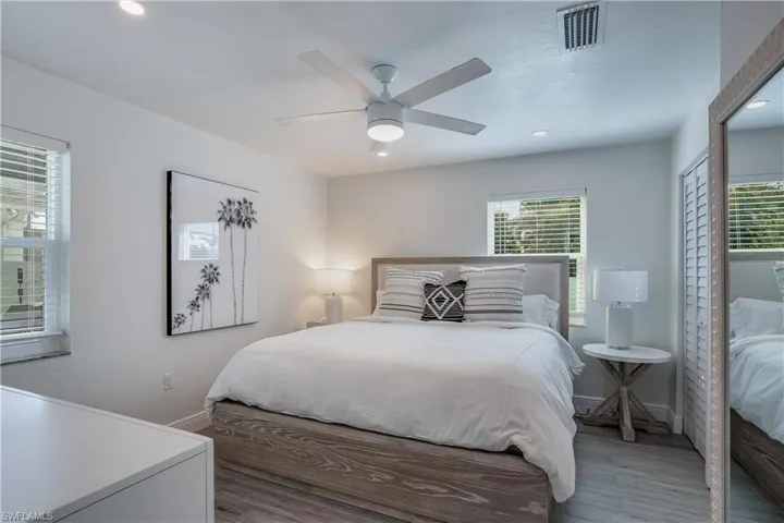 Bedroom with baseboards, visible vents, a ceiling fan, wood finished floors, and recessed lighting