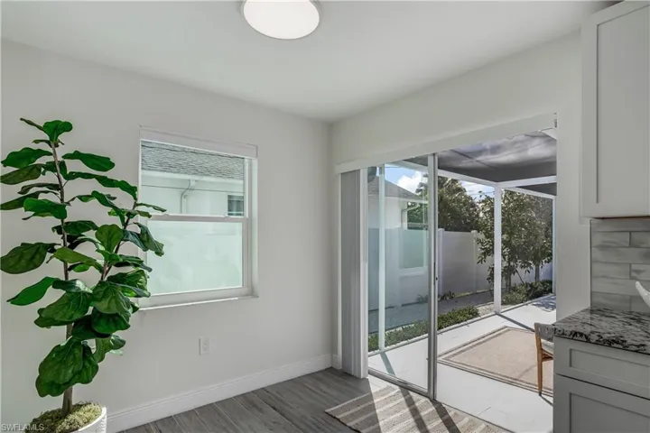 Doorway featuring light wood-style floors, baseboards, and a sunroom