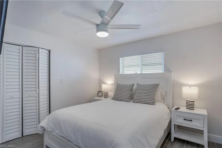 Bedroom featuring dark wood-style floors, a closet, and a ceiling fan