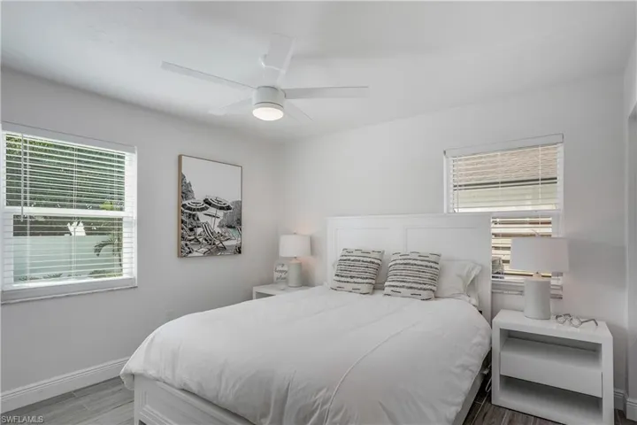 Bedroom featuring a ceiling fan, baseboards, and wood finished floors