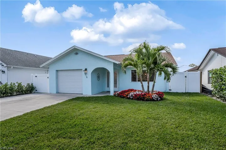 Ranch-style house with a garage, concrete driveway, a front lawn, and stucco siding