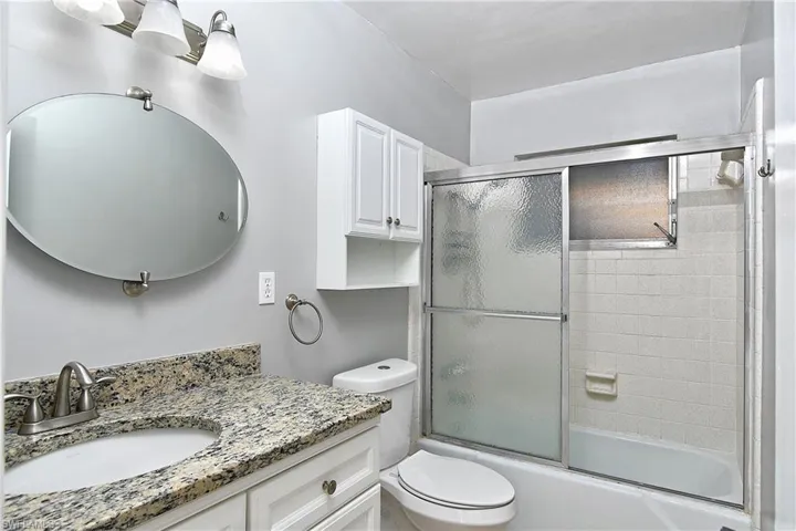 Full bathroom with toilet, vanity, tile patterned floors, and shower / bath combo with sliding door