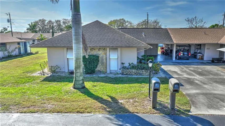 Ranch-style home with a front yard and a carport