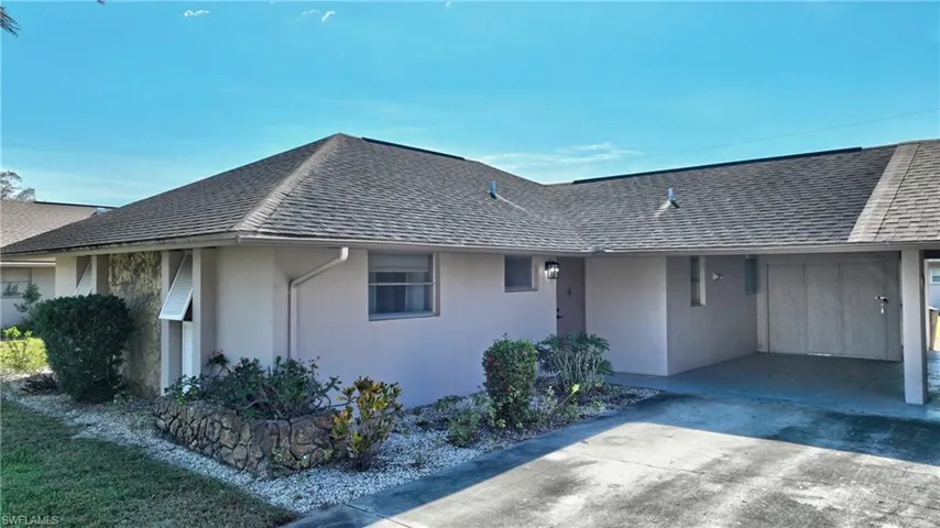 Single story home with a front yard and a carport