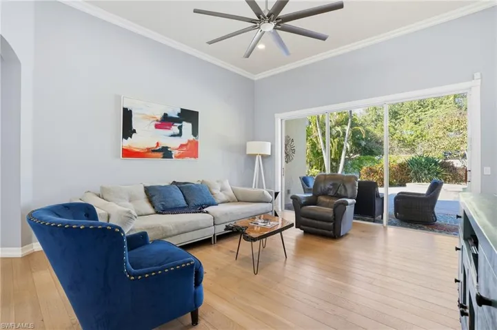 Living area featuring light wood-style flooring, ornamental molding, recessed lighting, arched walkways, and ceiling fan