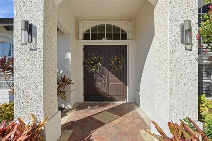 Doorway to property featuring stucco siding