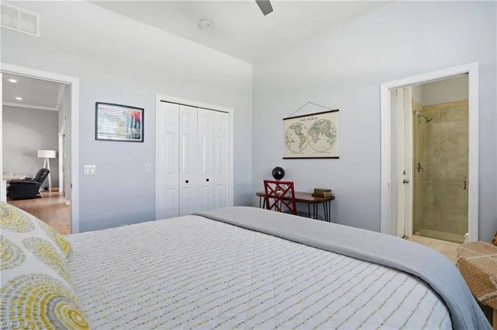 Bedroom with a closet, a ceiling fan, and ensuite bath