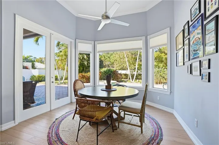 Dining area with light wood finished floors, crown molding, and a ceiling fan