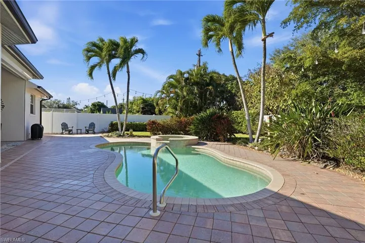 View of pool featuring a patio area, a pool with connected hot tub, and a fenced backyard