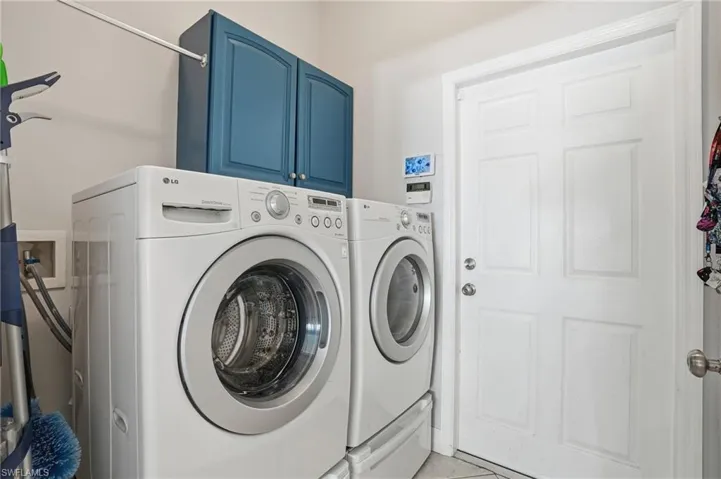 Laundry room featuring washing machine and clothes dryer and cabinet space