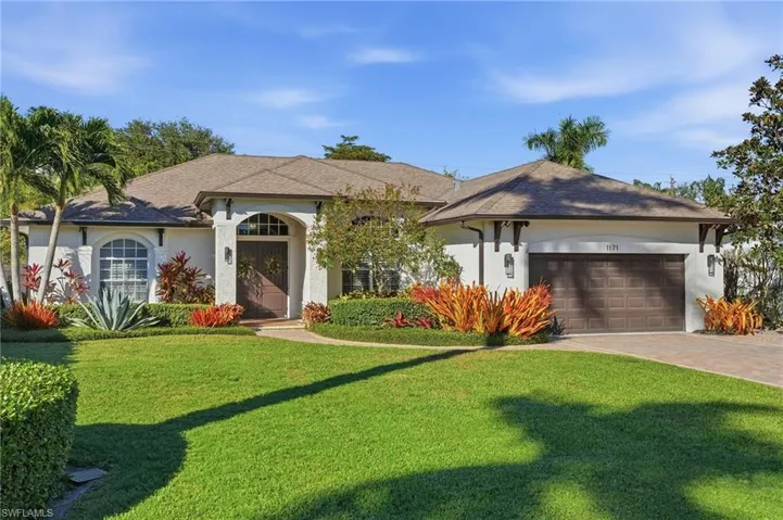 Ranch-style house featuring a front yard, stucco siding, decorative driveway, and a shingled roof