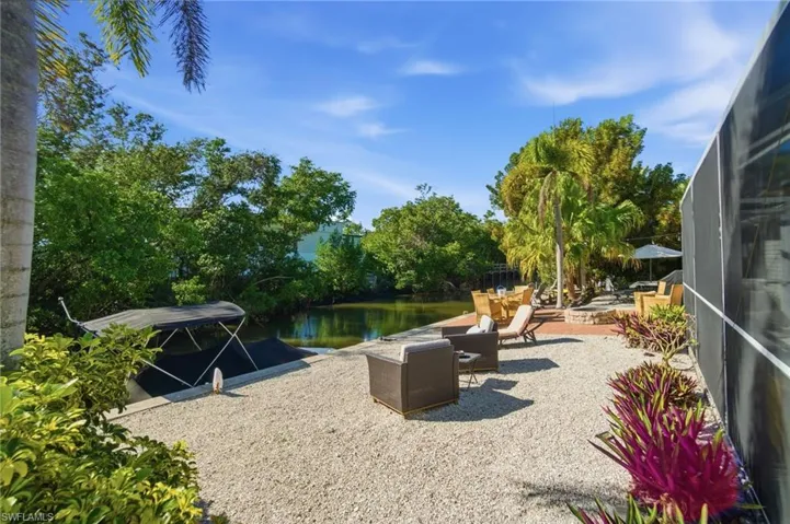 View of patio / terrace with a lanai, a water view, a boat dock, and a sunroom