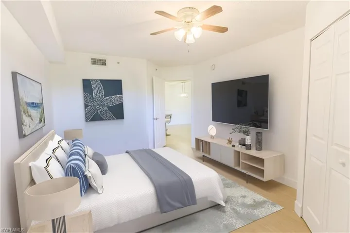 Bedroom with light wood-style floors, visible vents, and a ceiling fan