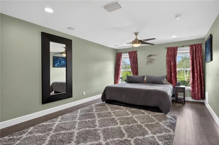 Master Bedroom featuring dark wood type finished floors, multiple windows, a ceiling fan, a textured wall, and recessed lighting