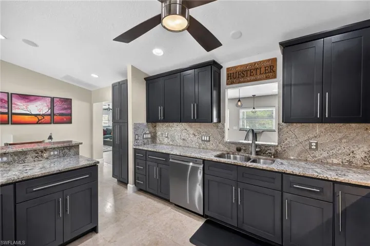 Kitchen featuring light stone countertops, dishwasher, ceiling fan, decorative backsplash, and recessed lighting