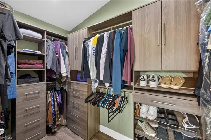 Walk in closet featuring vaulted ceiling and light wood-type flooring