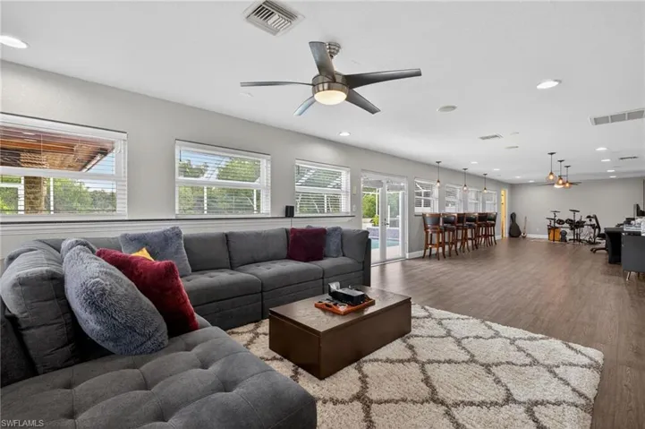 Living room featuring wood finished floors, a ceiling fan, recessed lighting, and french doors