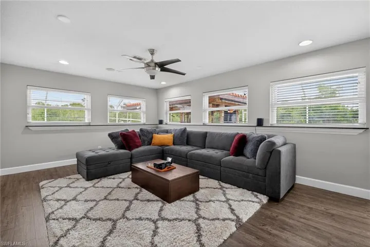 Living area with dark wood finished floors, a ceiling fan, and recessed lighting