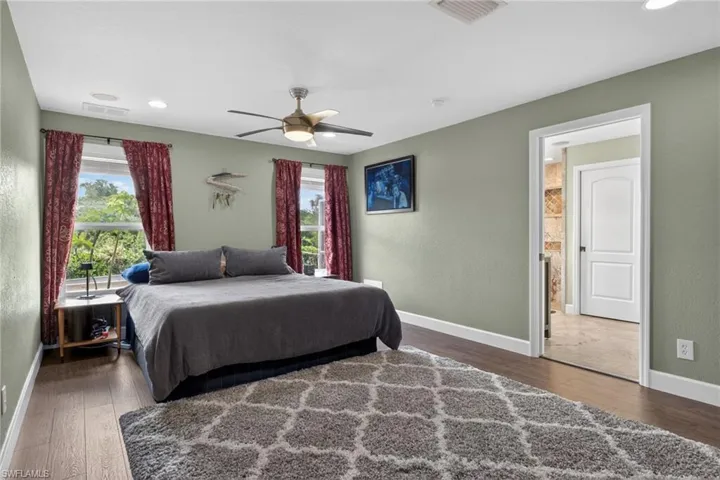 Master Bedroom featuring wood-type finished floors, multiple windows, a ceiling fan, a textured wall, and recessed lighting