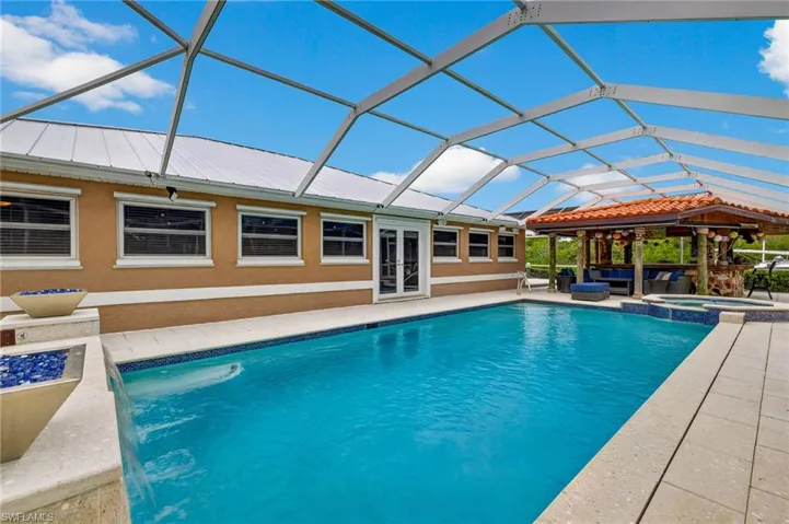 Combined pool / hot tub with a patio area, french doors, a lanai, and a family room/sunroom