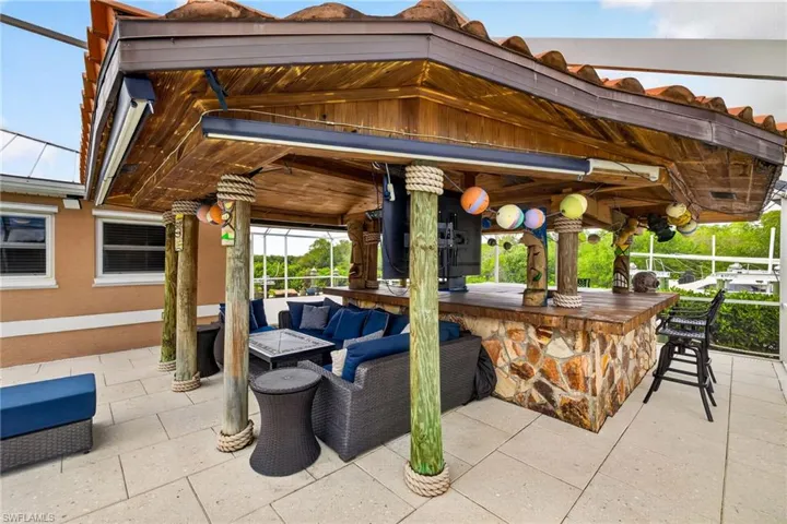 View of patio with an outdoor lounge area with bar