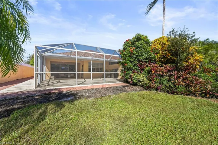Back of property with a sunroom, glass enclosure, and a patio area