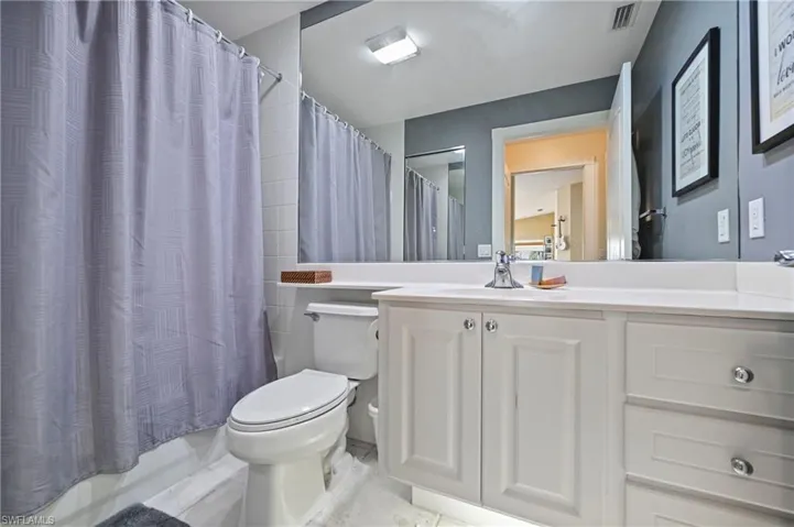 Bathroom featuring vanity and shower / bath combo with shower curtain