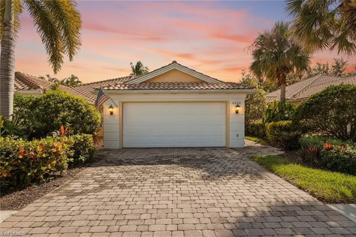 Mediterranean / spanish-style home with a tile roof, decorative driveway, and a garage